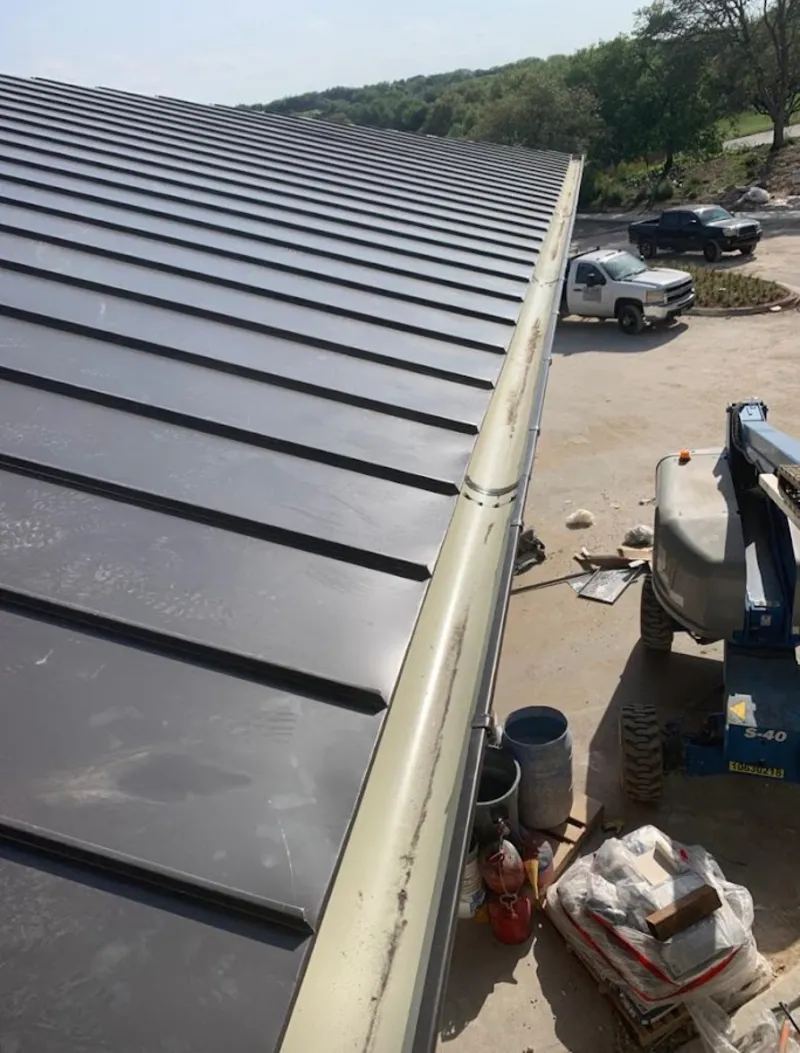 Standing seam panel and gutter detail on a metal roofing jobsite in Fairview